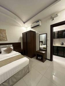 Schlafzimmer mit einem Bett und einem Spiegel in der Unterkunft Lilas Taif in Ta'if