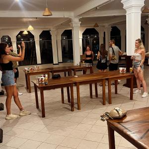 a group of people standing in a room with tables at Hummus Hostel & Restaurant in Hikkaduwa