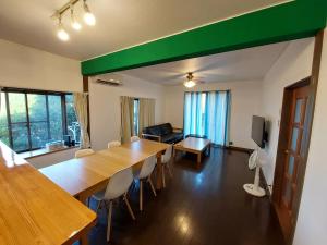 een woonkamer met een grote houten tafel en stoelen bij UMICHIKA AOSHIMA - Private house in Miyazaki