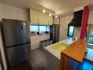 een keuken met een roestvrijstalen koelkast en een aanrecht bij UMICHIKA AOSHIMA - Private house in Miyazaki