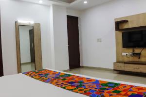 1 dormitorio con 1 cama con una alfombra colorida en el suelo en FabHotel Bell Inn, en Nueva Delhi