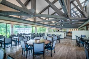 a dining room with tables and chairs and windows at Crowne Plaza Atlanta SW - Peachtree City, an IHG Hotel in Peachtree City