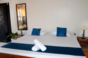 a bedroom with a white bed with blue pillows at Upaja Ghar Homestay in Guwahati