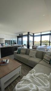 a living room with a couch and a table at Heart of Torquay - Whitewater Apartment - Torquay in Torquay