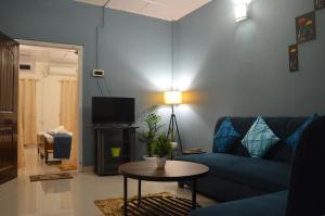 a living room with a blue couch and a table at Upaja Ghar Homestay in Guwahati