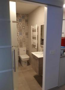 La salle de bains est pourvue de toilettes et d'un lavabo. dans l'établissement Acogedor apartamento nuevo en Puebla de Lillo, à Puebla de Lillo