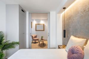 1 dormitorio con 1 cama, 1 silla y 1 mesa en Magno Apartments Zaragoza, en Sevilla