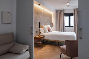 a hotel room with a bed and a couch at Magno Apartments Zaragoza in Seville +2 photos