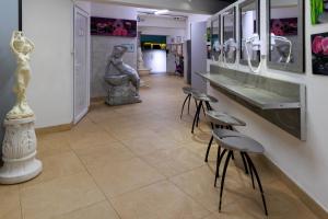 a hallway with sculptures and stools in a museum at Logis Hôtel Le Rochelois in La Rochelle