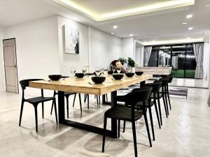 a dining room with a large wooden table and chairs at Number3 Poolvilla Bangkok in Lat Krabang