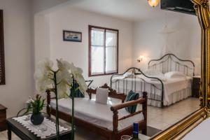 a bedroom with two beds and a mirror at Villa Notos in Adamas
