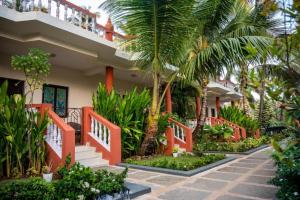 a house with palm trees in front of it at Vintage Beach Resort in Agonda