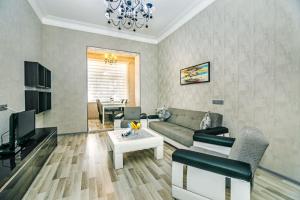 a living room with a couch and a table at Azneft Square Deluxe Apartment in Baku