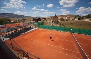 una persona jugando al tenis en una pista de tenis en Apartman NS Zlatibor en Zlatibor