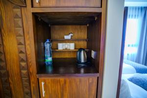 ein kleiner Schrank mit einer Flasche Wasser in einem Schlafzimmer in der Unterkunft Petra Icon Hotel in Wadi Musa