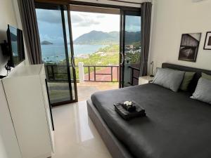 a bedroom with a bed with a view of the ocean at Harbour View Villa in Koh Tao