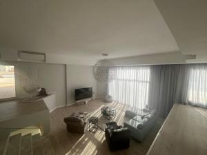 vilaa rudah في الرياض: غرفة معيشة مع أريكة وتلفزيون