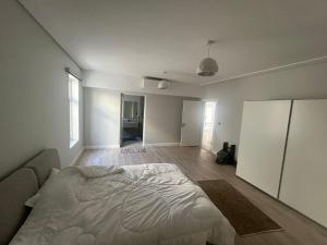 vilaa rudah في الرياض: غرفة نوم بيضاء مع سرير وغرفة معيشة