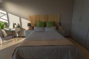 a bedroom with a large bed with green pillows at Views from the Top in Edenvale