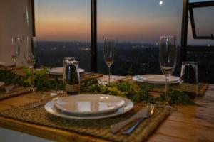 a table with plates and glasses on a table with a view at Views from the Top in Edenvale
