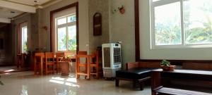 Song Toan Hotel في فونغ نها: غرفة معيشة مع غرفة مع نوافذ وسخان