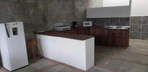 une cuisine avec un réfrigérateur blanc et un évier dans l'établissement Casa Linda, à San Pedro de la Laguna