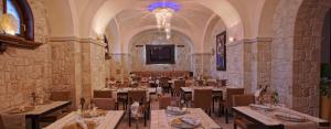 a restaurant with tables and chairs and a chandelier at Hotel Cenacolo in Somma Vesuviana