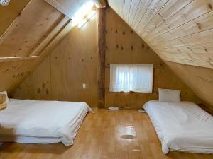 two beds in a room with a attic at Log Park Dochidol Ranch in Jeju