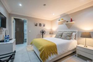 a bedroom with a large bed and a television at Nazari House in Cape Town