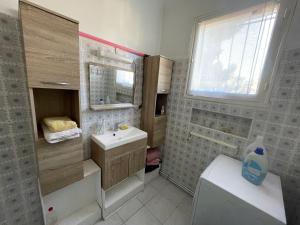 uma casa de banho com um lavatório, um WC e uma janela. em Cote Bleue em Carry-le-Rouet