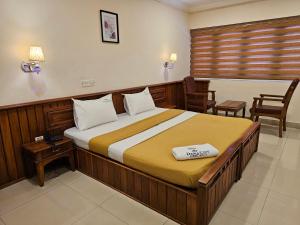 um quarto com uma cama grande num quarto em Deira City Residency em Kasaragod