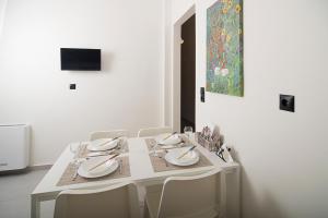 a white dining room table with chairs and a painting at Dream apartment next to the sea in Kyparissia