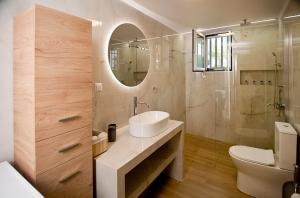 a bathroom with a sink and a toilet and a mirror at Dream apartment next to the sea in Kyparissia