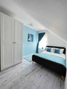 a bedroom with a bed with blue walls and wooden floors at Eduard Inn in Vulcan