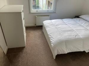 1 dormitorio con cama blanca y ventana en Two double bedroom flat in Soho, en Londres