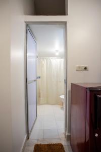 a bathroom with a glass door leading to a shower at Hill Top Nest in Vagator