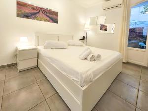 Una cama blanca en una habitación con toallas. en Le Château 4 Pers AC WiFi Vecchia Nizza, en Niza