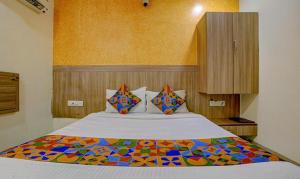 a bedroom with a large bed with a colorful blanket at FabExpress Prakash Inn in Mumbai