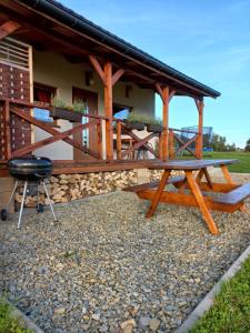 a picnic table and a grill in front of a house at Domki POD STARĄ PODKOWĄ Limanowa Nowy Sącz Kraków in Limanowa