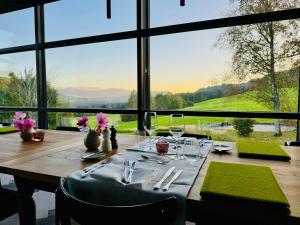 a dining room table with a view of the mountains at Alpenloge Boutique Hotel in Scheidegg