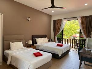 a bedroom with two beds and a balcony at Red Coral Cottage in Tanjung Rhu 