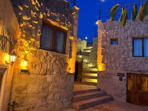 a stone building with stairs leading up to a door at Kale House Nar in Nevsehir