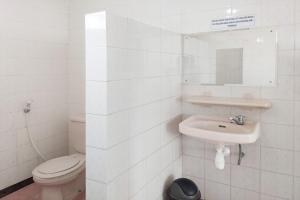 a white bathroom with a sink and a toilet at Vanda Villa in Batu