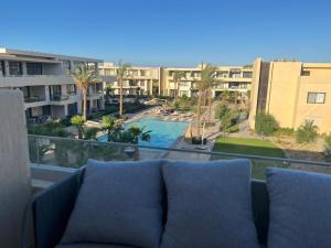 a couch on a balcony with a view of a resort at Studio EL Gouna G-Cribs in Hurghada