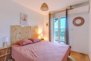 una camera da letto con un letto e una grande finestra di La Terrasse a La Teste-de-Buch