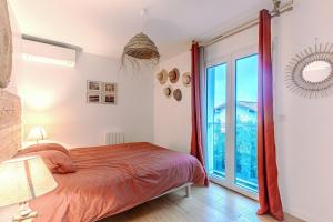 una camera da letto con un letto e una grande finestra di La Terrasse a La Teste-de-Buch Altre 5 foto