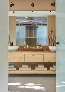 a bathroom with two sinks and a large mirror at Kwandwe Ecca Lodge in Grahamstown