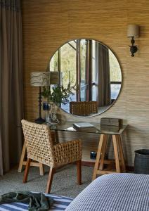 a bedroom with a desk with a mirror and a chair at Kwandwe Ecca Lodge in Grahamstown