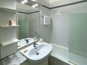 Un baño blanco con lavabo y ducha en Navigli Suites, en Milán