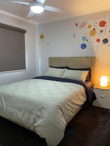 sypialnia z łóżkiem i wentylatorem sufitowym w obiekcie Family Home in Riverdale Village Town Tarneit w mieście Tarneit